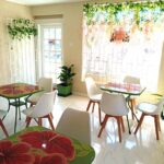 Hibiscus Cafe Oistins Barbados Interior View Showing Modern crisp look with hand painted tables and white scandinavian chairs