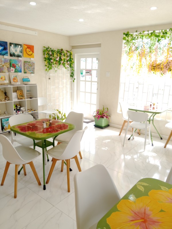 Hibiscus Cafe Oistins Barbados Interior View of a cozy cafe with hand painted tables and floral accents